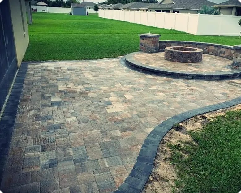Paver patio with a raised fire pit and dark border