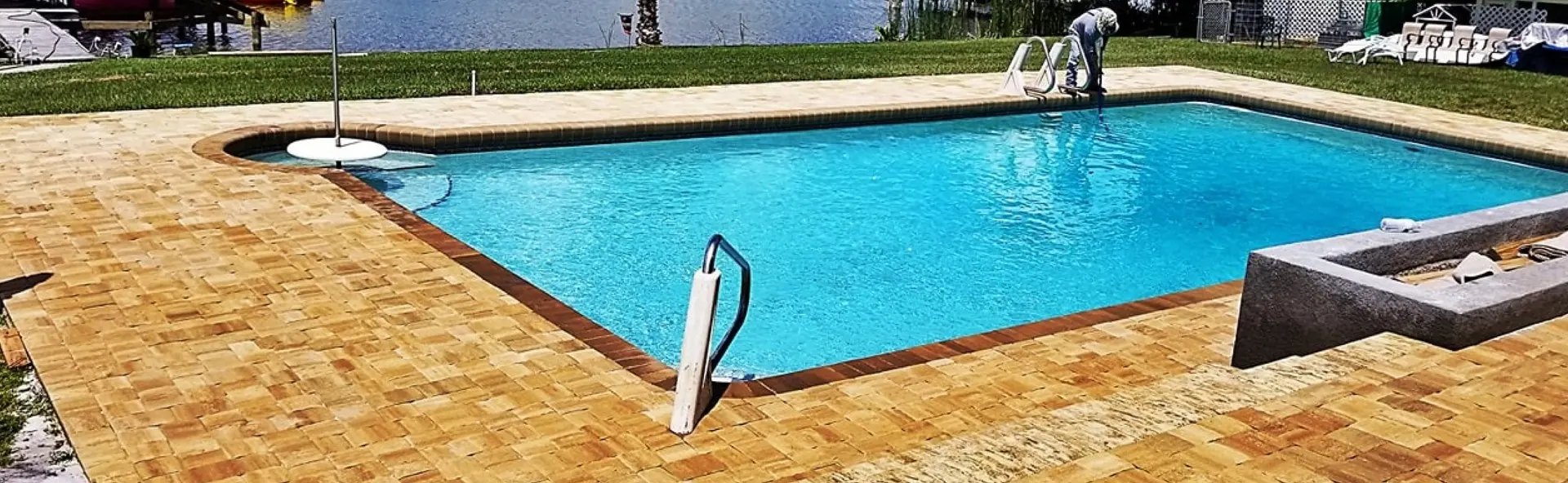 Paver pool deck meeting a green lawn