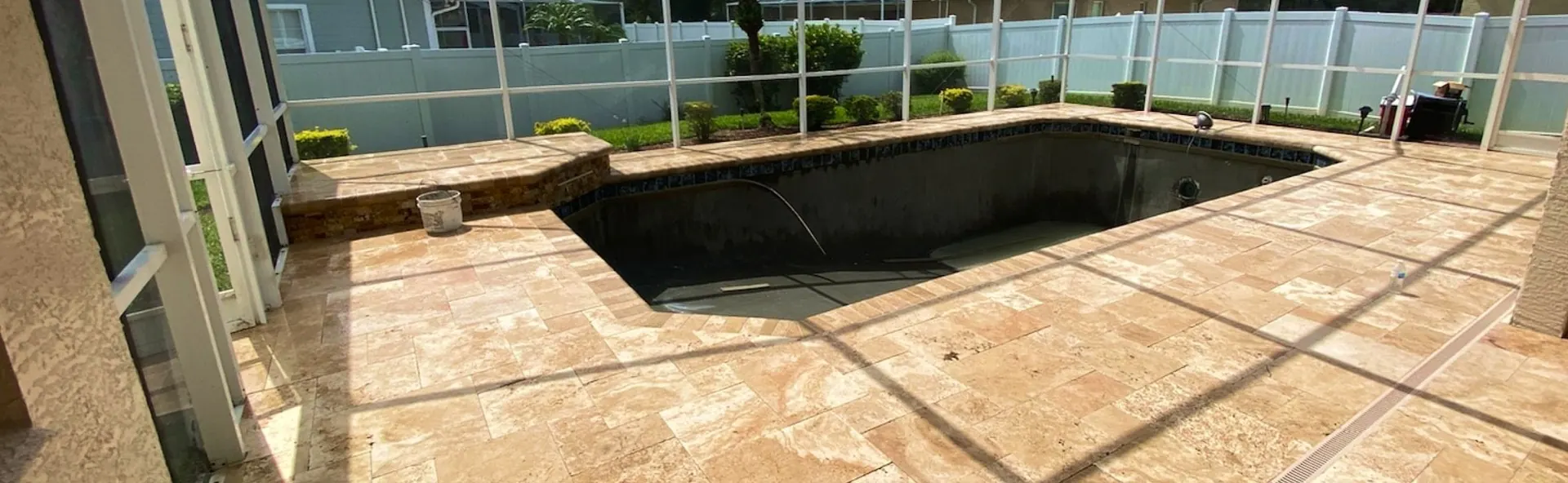 Screened pool deck framed by hedges